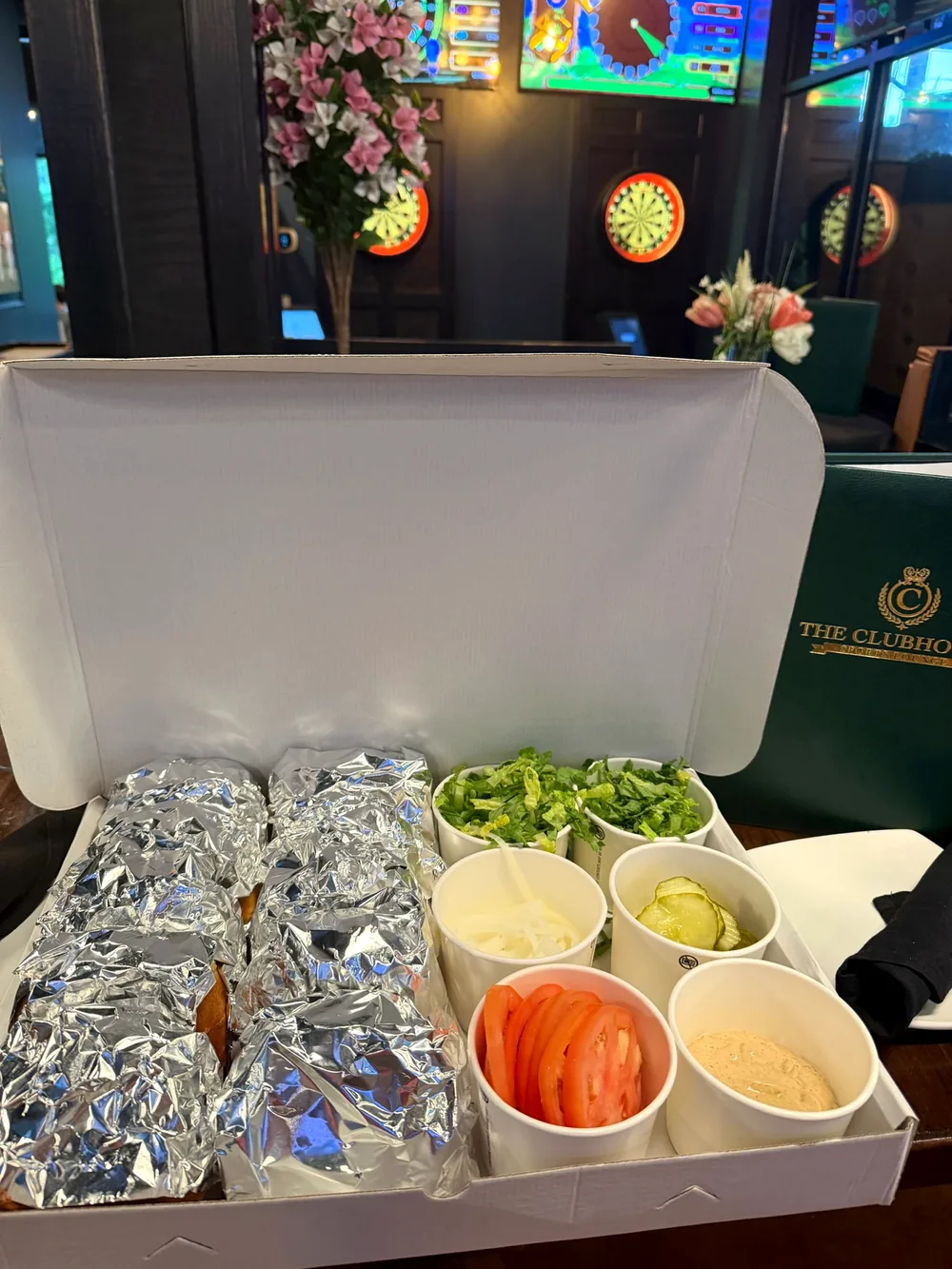 Clubhouse boxed burger catering with lettuce, tomato, pickles and sauces
