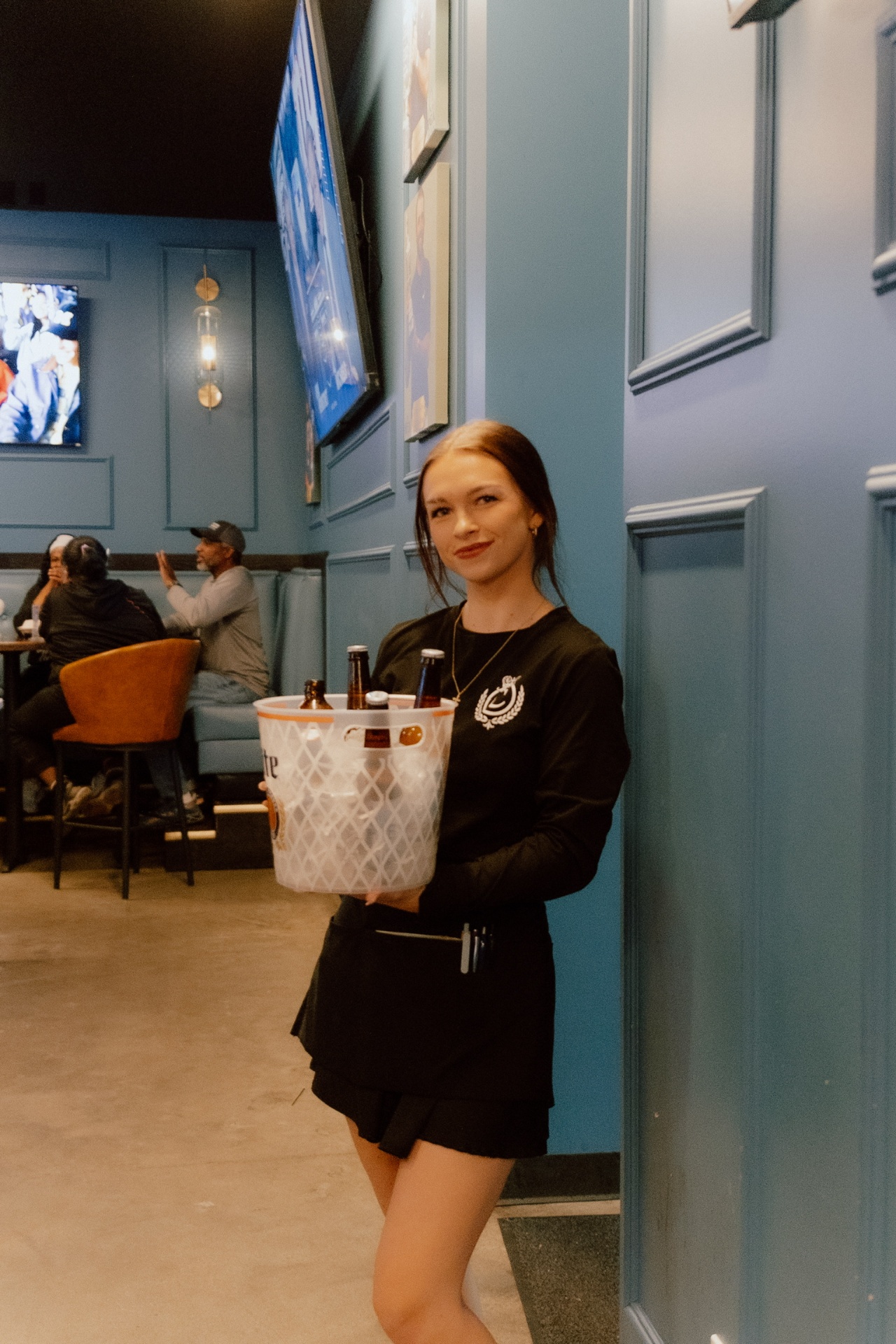 Server delivering a bucket of beers