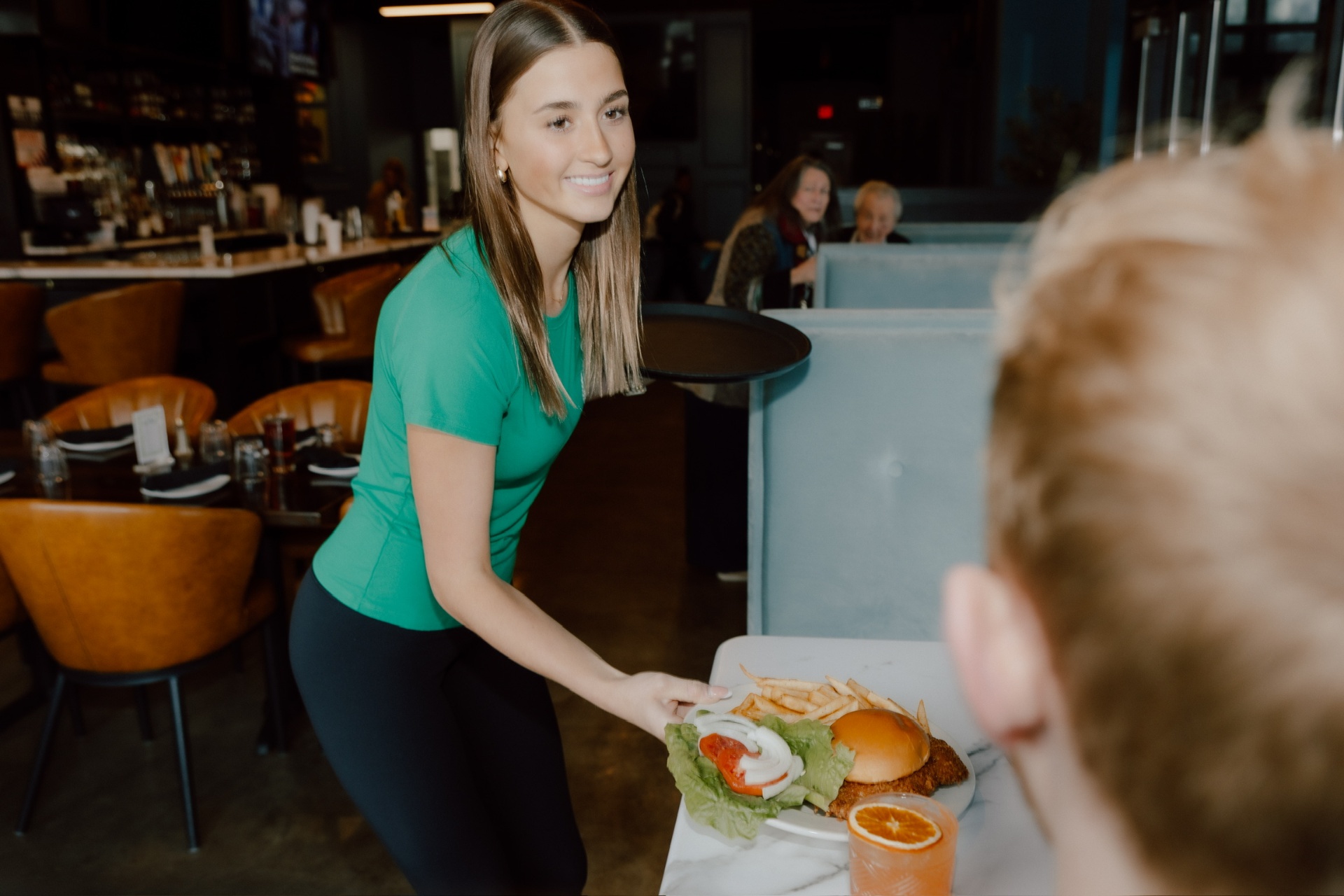 Server delivering a burger plate